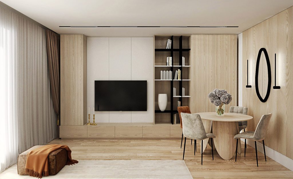 În acest living room cu zonă pentru servit masa am îmbinat elemente minimaliste în tonuri calde alături de materiale confortabile. Piesele cu colțuri rotunjite și forme atipice alături de grafica tapetului, care schițează o panglică în bătaia vântului, sunt elemente ce aduc natura în spațiul amenajat.